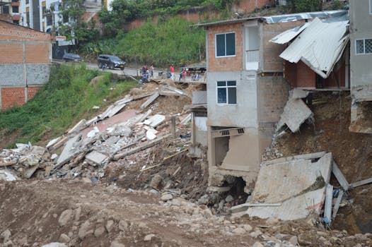 A residential building partially collapsed due to a natural disaster, showcasing severe structural damage.
